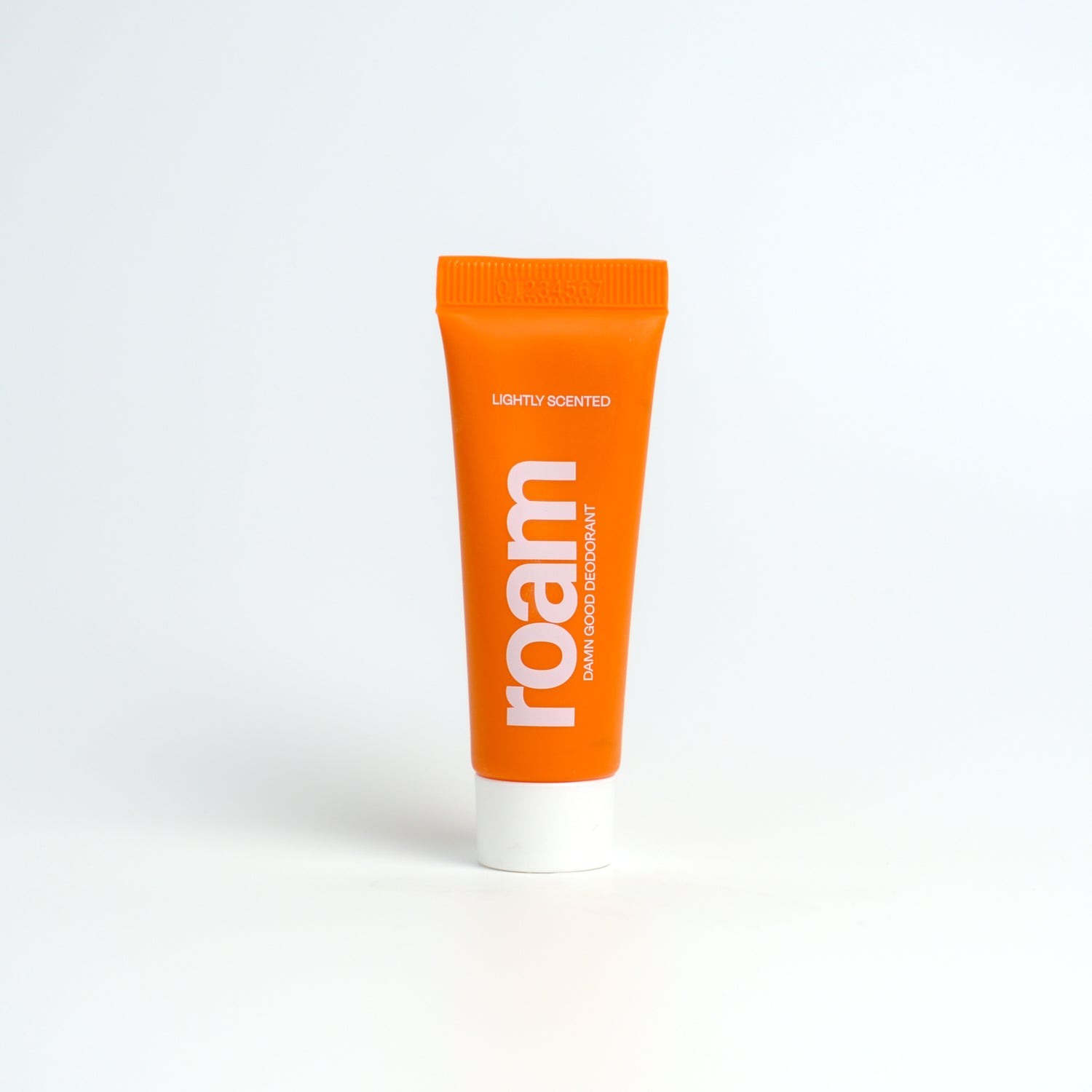 Orange tube of roam deodorant on a white background