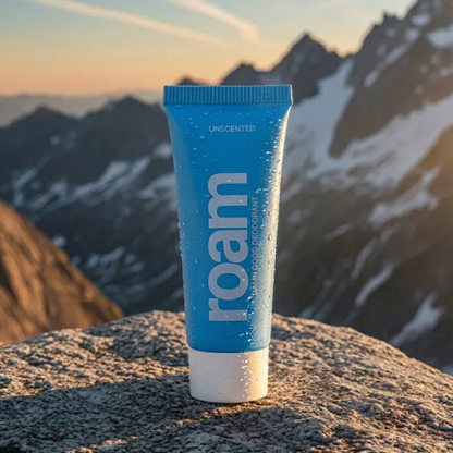 Blue tube of 'roam' deodorant on a rock with mountains in the background
